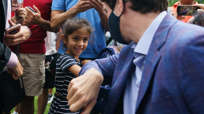 Justin Trudeau saludando a un infante